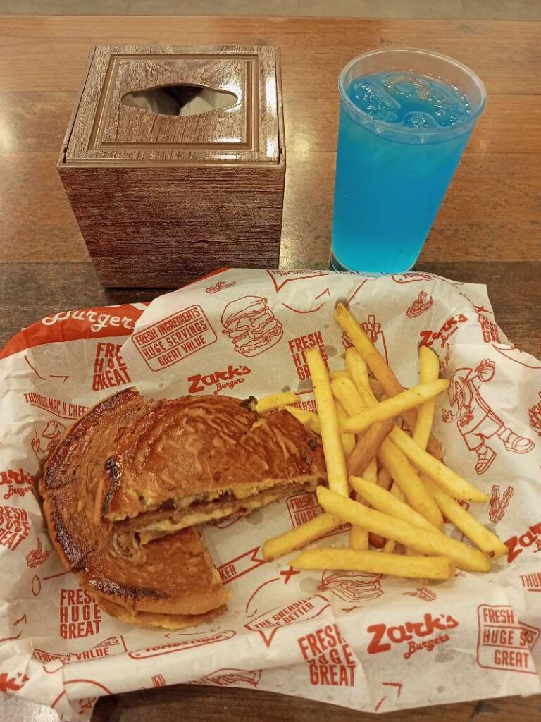 Zark's Burgers Cheeseburger, French Fries, and Blue Lemonade with a box of plastic hand gloves.