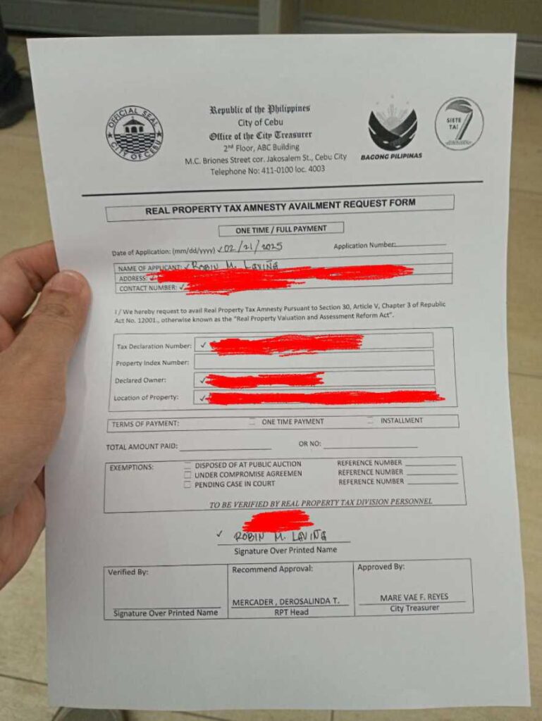 A photograph of a Real Property Tax Amnesty Availment Request form. The form is filled out partially, with some information redacted. The form includes sections for applicant information, property details, payment terms, exemptions, and verification signatures. The City Treasurer's office letterhead is visible at the top.