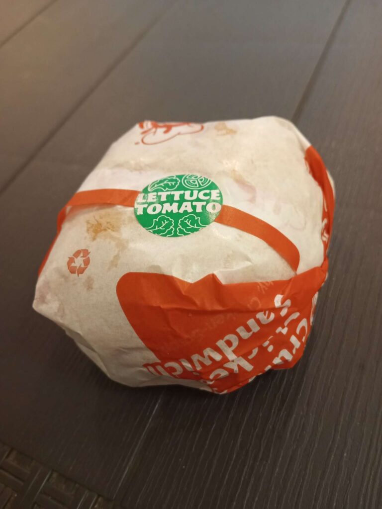 Jollibee packaging their sandwiches with a lettuce and tomato green sticker for labelling.